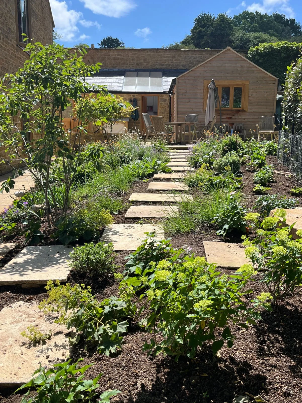 A finished cottage garden with sandstone steps, paths and planted borders