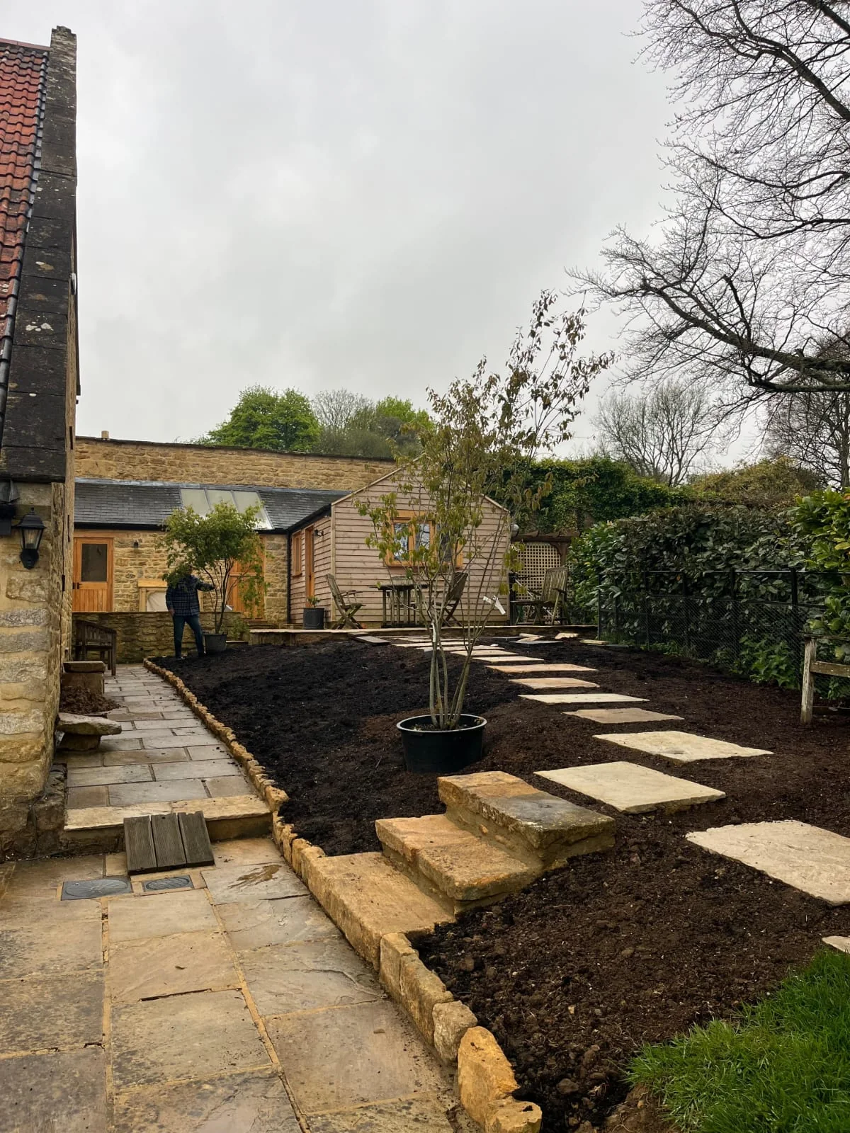 Sandstone garden steps leading through newly landscaped borders